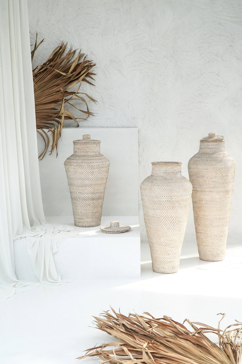Διακοσμητικό βάζο Bima από LOMBOK KETAΚ σε white wash απόχρωση. Σε μακρόστενο σχήμα με καπάκι και πλεκτή όψη. Μια πιο μοντέρνα έκδοση του κλασικού ψηλού πιθαριού με καπάκι.