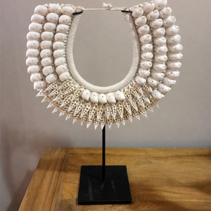 Εντυπωσιακό χειροποίητο διακοσμητικό κολιέ από φυσικά κοχύλια, τοποθετημένο σε κομψή μεταλλική βάση. Ένα μοναδικό statement piece που αποπνέει εξωτική αισθητική και φέρνει την αύρα της θάλασσας στον χώρο σας. Ο συνδυασμός από λευκά γυαλιστερά κοχύλια και διακοσμητικά κωνικά κοχύλια δημιουργεί πλούσια υφή και εντυπωσιακό οπτικό αποτέλεσμα. Ιδανικό για boho, ethnic, coastal ή φυσική διακόσμηση, ταιριάζει υπέροχα σε σαλόνι, είσοδο, κονσόλα ή επαγγελματικό χώρο. Κάθε κομμάτι είναι χειροποίητο και μοναδικό, προσδίδοντας αυθεντικότητα και χαρακτήρα στον χώρο.